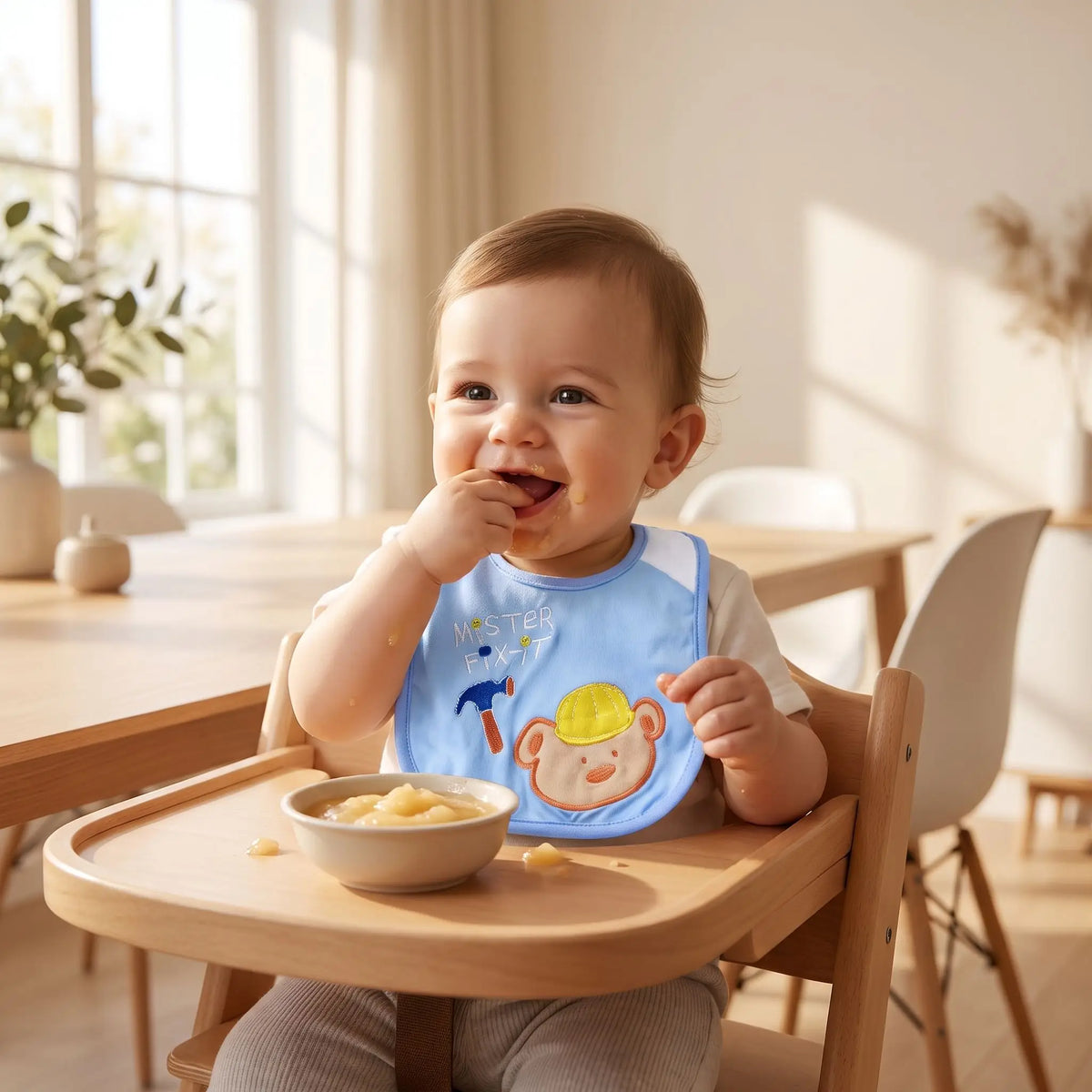Bébé souriant portant un bavoir bleu avec des dessins animés