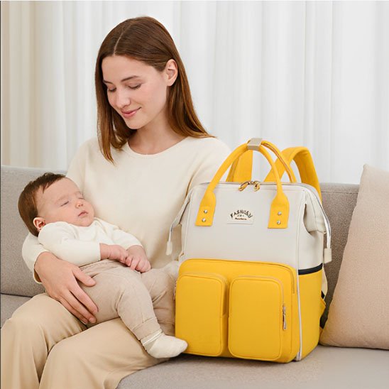 Sac a langer, couleur blanc jaune maman assise regardant son bébé